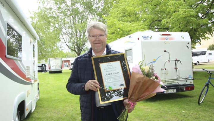 Man står med diplom för Sveriges Husbilsvänligaste Kommun i handen.